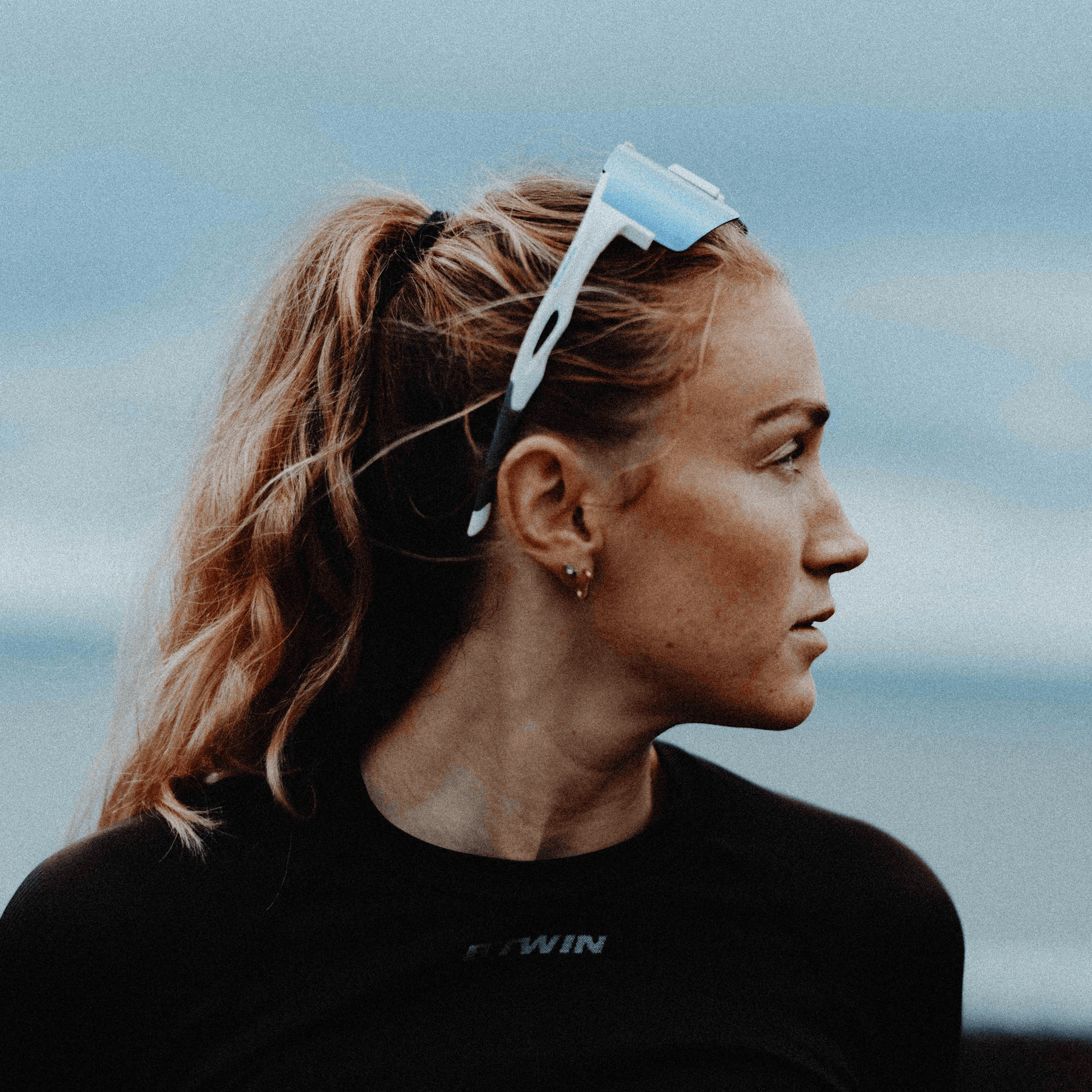 Female runner wearing Kukuna Performance sunglasses with white frame and ice blue mirror lenses