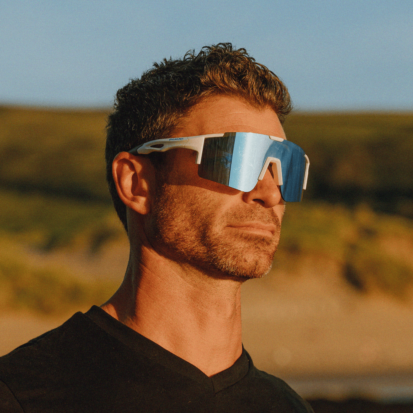 Male runner wearing Kukuna Performance sunglasses with white frame and ice blue mirror lenses